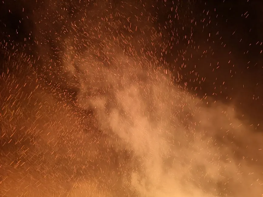 Orange light sparks rising in the dark