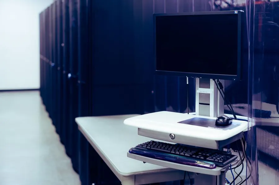 A workstation next to server cabinets