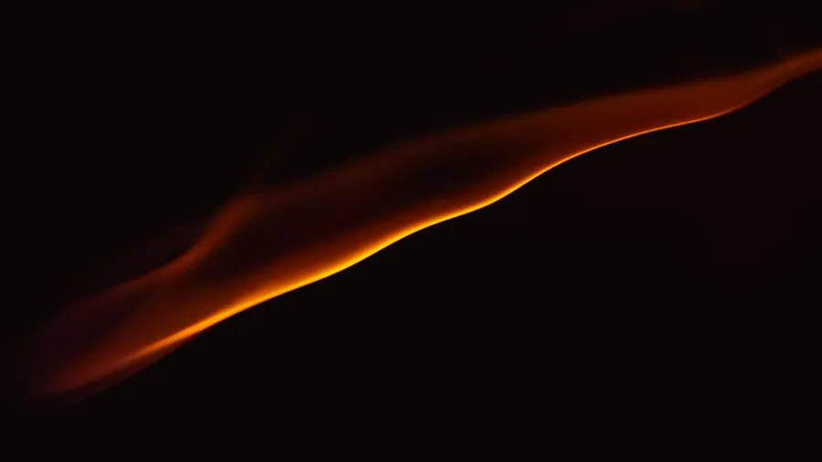An orange light wave on a black background, like a trend curve